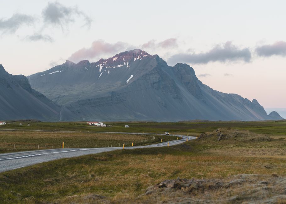 Breathtaking view of Icelandic mountains with a winding road at twilight, showcasing natural beauty and serenity.