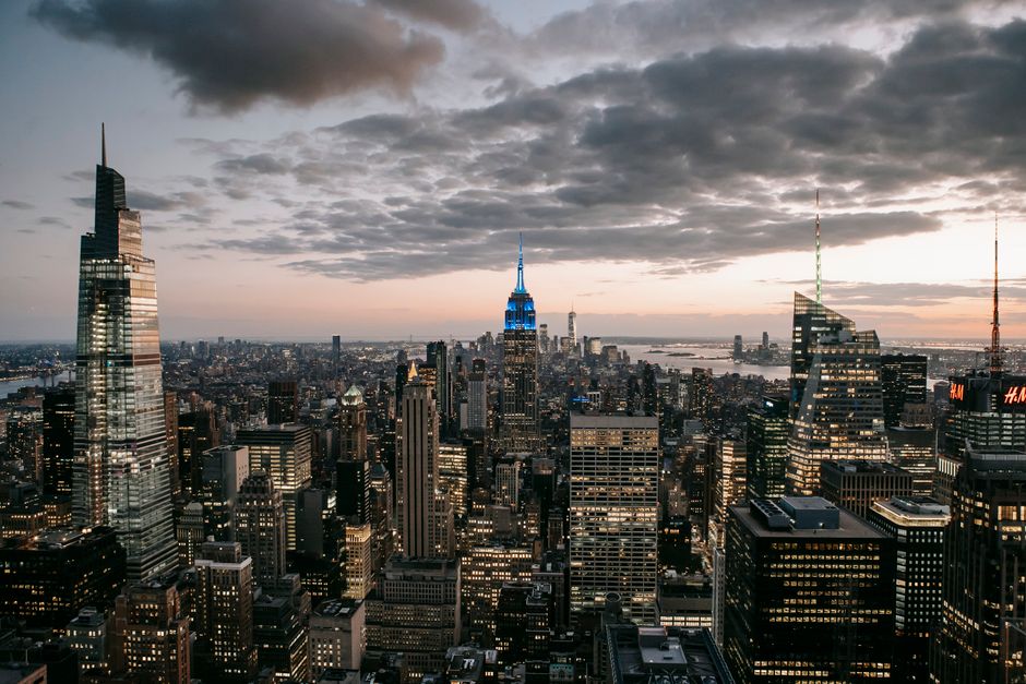 Modern skyscraper exteriors against endless ocean under cloudy sky in New York City at sundown