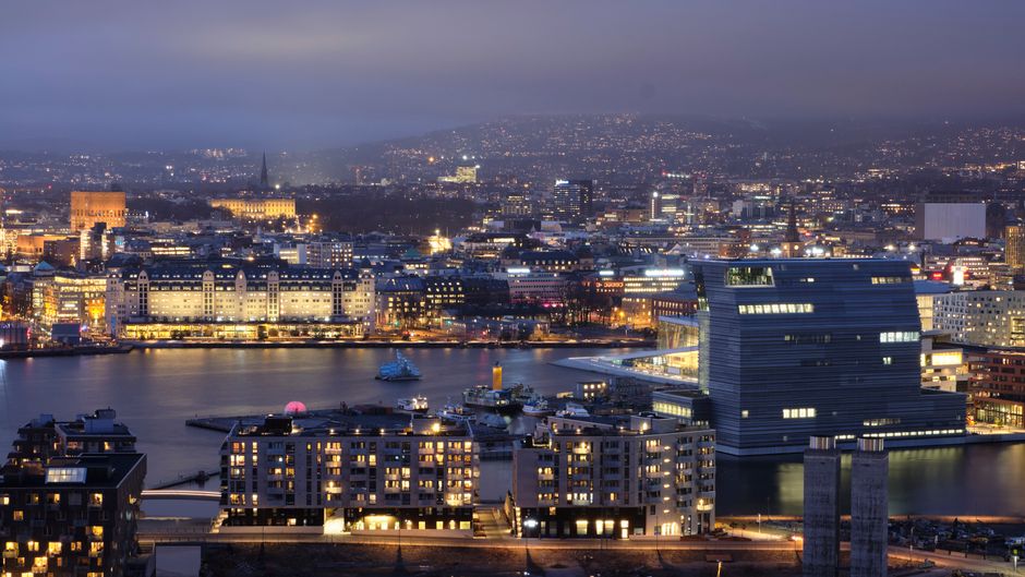 Discover the illuminated skyline of Oslo, Norway, capturing the vibrant urban lights at dusk.