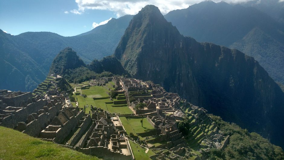 A stunning view of Machu Picchu, the ancient Incan citadel in the Andes mountains of Peru, under a clear sky.